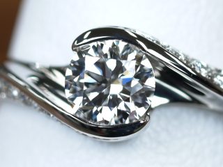 ダイヤモンドを包み込むようなデザインの婚約指輪