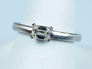 エメラルドカットを横向きに留めた婚約指輪。普段使いしやすい、お洒落なデザインです。