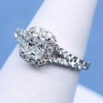クッションカットセンターダイヤとパヴェセッティングのアームが輝くエレガントな婚約指輪。立体感のあるデザインが魅力。